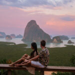 A couple of men and woman watching the sunrise at Sametnangshe viewpoint in Phangnga Bay with mangrove forest in the Andaman Sea, Sametnangshe mountain Phangnga, Thailand