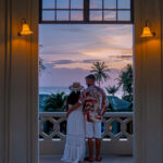 men and women watching the sunset of a balcony of their condo apartment by the ocean in Thailand.