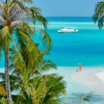 Three year old toddler boy on beach with mother. Summer family vacation at Maldives.