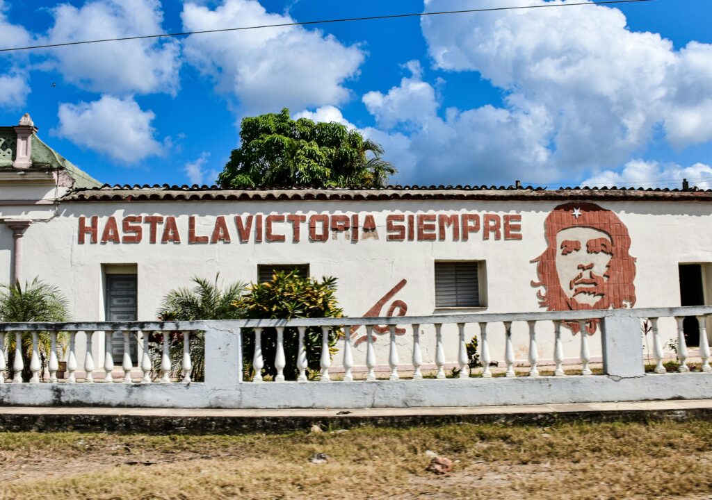 Colorful mural of Che Guevara on a wall in Santa Clara, Cuba, under a bright blue sky.