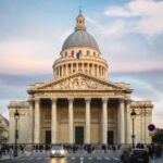 The Pantheon surrounded by people under a cloudy sky during sunset in Paris in France