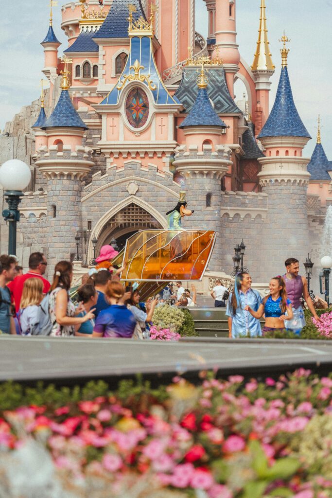 Vibrant scene at Disneyland Paris with iconic Sleeping Beauty Castle and crowd enjoying the atmosphere.