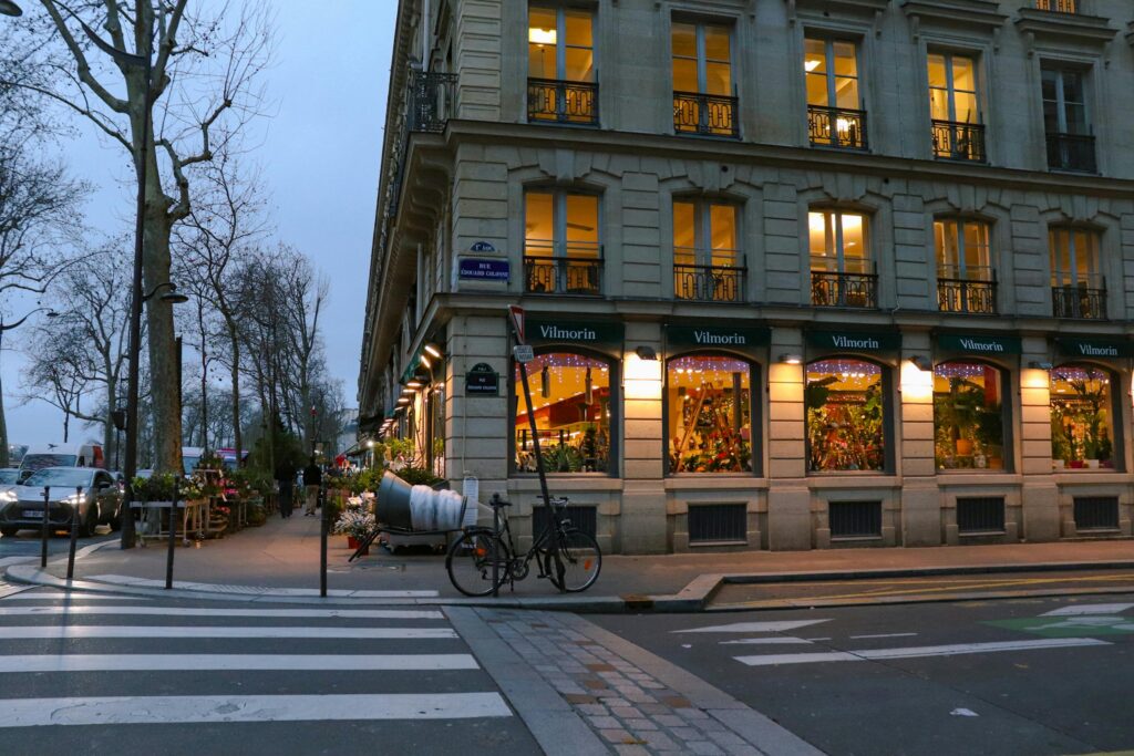 A picturesque evening view of a Paris street corner with charming architecture and warm lights.