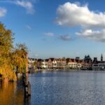 View over the Spaarne river in Haarlem with autumn coloured trees on a beautiful day in november