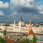 An aerial shot of Hungarian Parliament Building in Budapest, Hungary under a cloudy sky