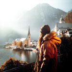 woman in orange jacket standing on brown wooden dock during daytime