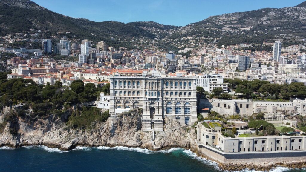 Breathtaking aerial view of the Oceanographic Museum amidst Monaco's coastline and urban landscape.