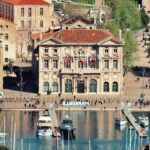 A vibrant view of Marseille City Hall by the waterfront, capturing boats and urban life.