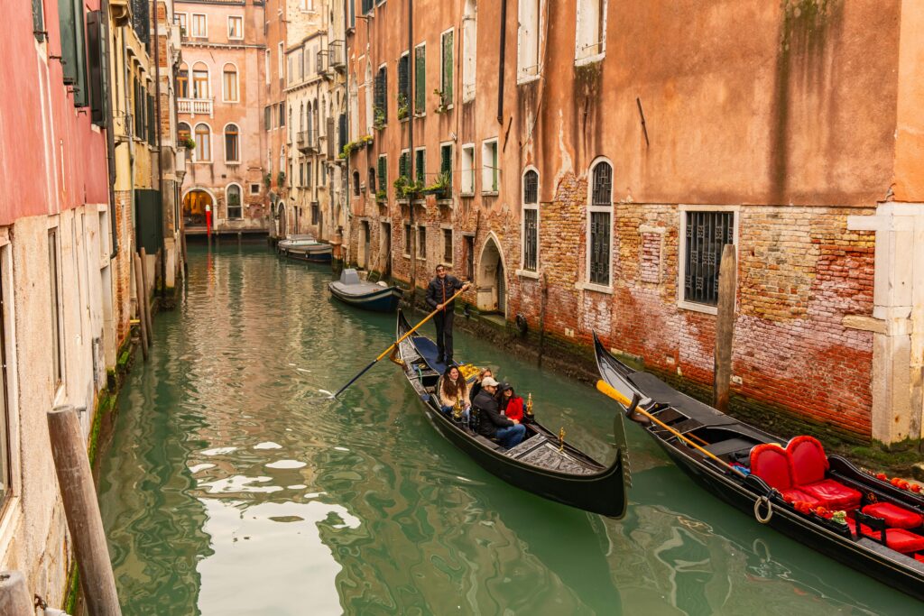 Gondolas on a charming Venetian canal surrounded by historic architecture in Venice, Italy.