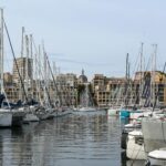 Stunning view of sailboats docked at the Old Port of Marseille with cityscape backdrop.