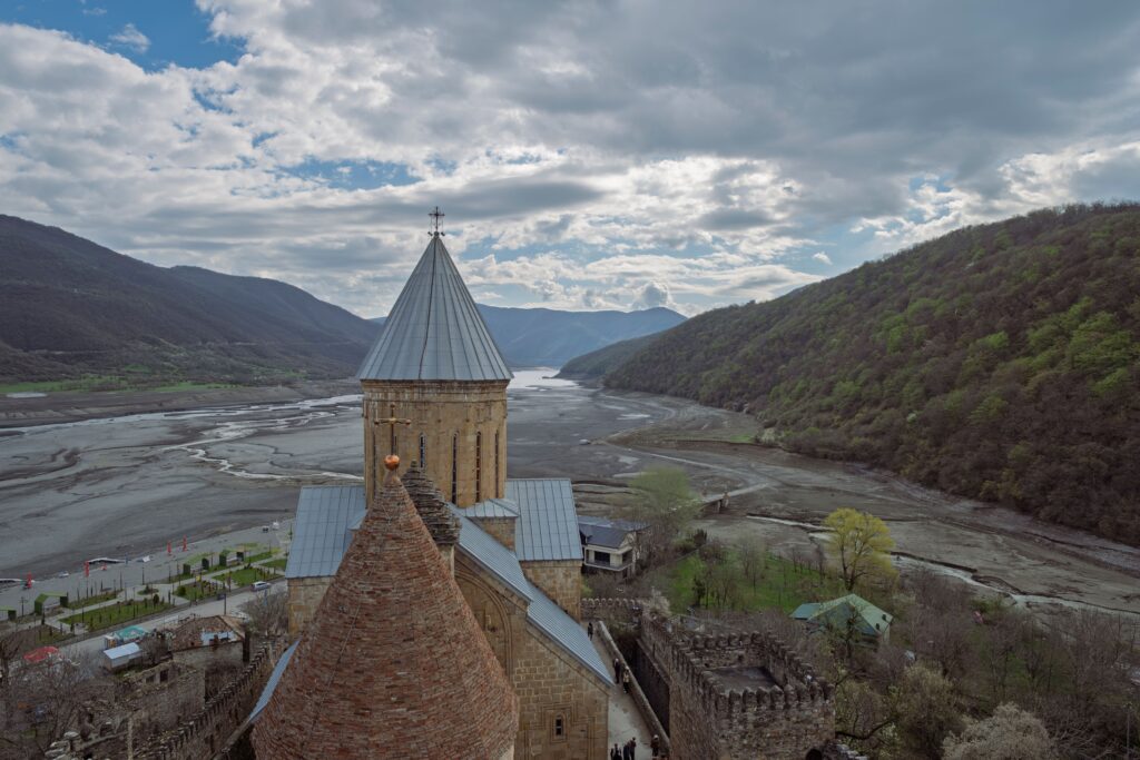 Breathtaking aerial view of Ananuri Fortress with scenic mountains and river in Mtskheta-Mtianeti, Georgia.