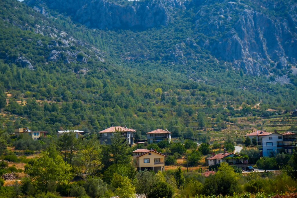 Charming rural village nestled among lush mountains on a sunny day.