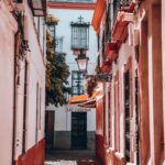 Explore a picturesque alleyway in Seville's historic district, capturing classic Spanish architecture.