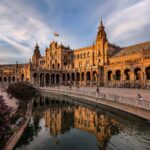 Beautiful sunset at Plaza de España showcasing Spanish architecture and reflections.