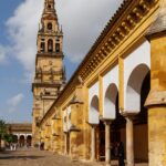 View of the iconic Mezquita-Cathedral with arched corridor and bell tower in Córdoba, Spain.