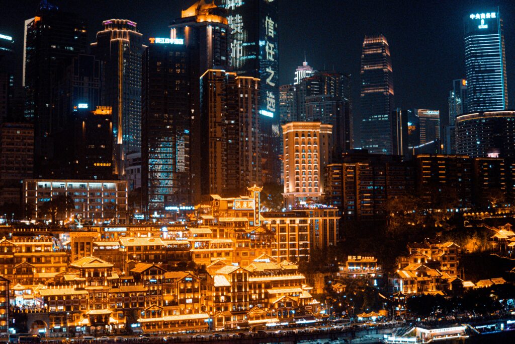 Illuminated view of Hongyadong in Chongqing cityscape at night showcasing traditional Chinese architecture and modern skyscrapers.