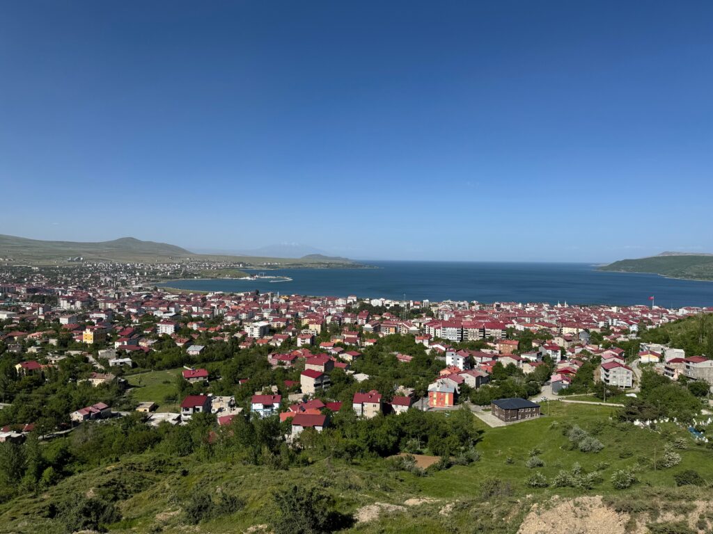 A picturesque aerial view of Tatvan city with Lake Van in the background under a clear sky.