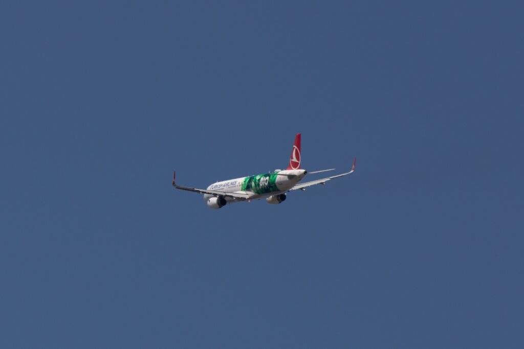 Turkish Airlines Airbus A320 soaring in the clear blue sky over Istanbul.